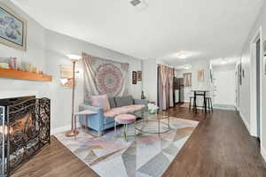 Living room with dark wood-type flooring and a textured ceiling