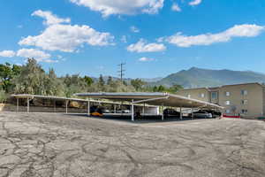 View of parking with a mountain view and a carport