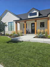 View of front of home with a front yard and a porch