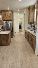 Kitchen featuring stainless steel fridge, a textured ceiling, and light hardwood / wood-style floors