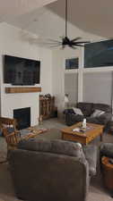 Carpeted living room with a textured ceiling and ceiling fan