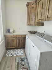 Laundry room featuring light hardwood / wood-style flooring, cabinets, and independent washer and dryer