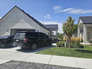 View of property exterior featuring a garage and a lawn