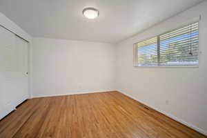 Unfurnished bedroom featuring a closet and wood-type flooring