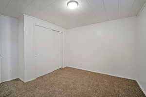 Unfurnished bedroom with a closet and carpet flooring