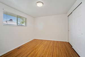 Unfurnished bedroom with hardwood / wood-style flooring and a closet