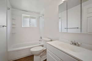 Full bathroom with wood-type flooring,  shower combination, vanity, and toilet