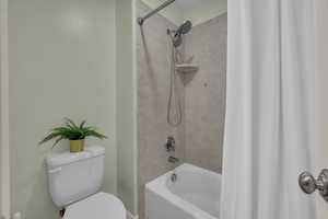 Bathroom featuring toilet and shower / bath combo