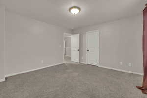 Unfurnished bedroom featuring carpet floors and a textured ceiling