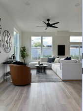 Living room with light hardwood / wood-style floors and ceiling fan