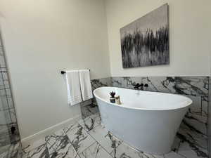 Bathroom featuring a bathtub and tile walls