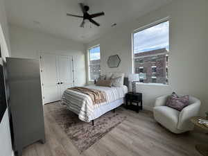 Bedroom with a closet, light wood-type flooring, and ceiling fan