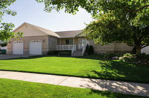 Ranch-style house featuring a front lawn and a garage