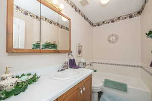 Bathroom with a bathtub, tile patterned floors, toilet, and vanity