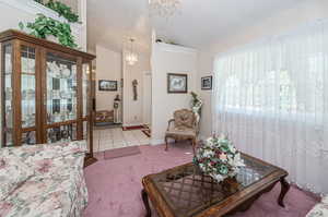 Tiled living room with lofted ceiling and a chandelier