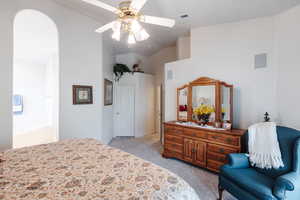 Bedroom featuring ceiling fan, light carpet, vaulted ceiling, and a closet