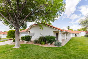 View of side of property featuring a garage and a lawn