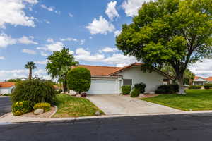 View of front of property featuring a front yard and a garage