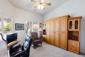 Office area featuring ceiling fan, vaulted ceiling, and light colored carpet