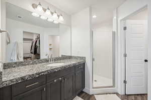 Bathroom with hardwood / wood-style floors, vanity, and walk in shower