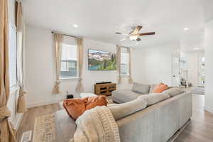 Living room with light wood-type flooring and ceiling fan