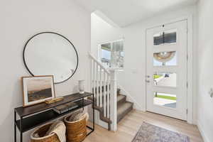 Foyer entrance featuring light wood-type flooring and a healthy amount of sunlight