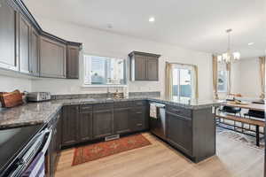 Kitchen with stainless steel dishwasher, light hardwood / wood-style flooring, sink, kitchen peninsula, and dark brown cabinets