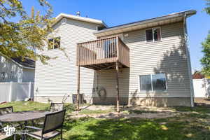 Back of property featuring central AC and a lawn