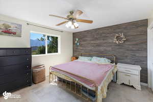 Tiled bedroom with wooden walls and ceiling fan