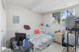 Tiled bedroom featuring electric panel