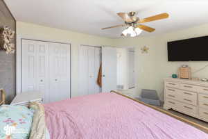 Bedroom featuring ceiling fan and multiple closets