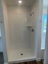 Bathroom with wood-type flooring and separate shower and tub