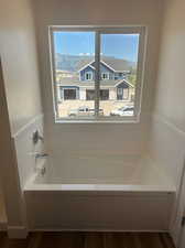 Bathroom with hardwood / wood-style floors, a bathtub, and a wealth of natural light