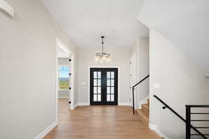 Foyer entrance featuring a notable chandelier and light hardwood / wood-style flooring