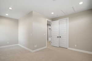 Unfurnished bedroom with a closet and light colored carpet