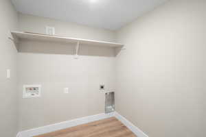 Laundry area with hardwood / wood-style floors, hookup for a washing machine, and hookup for an electric dryer