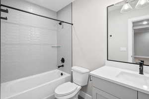 Full bathroom with tiled shower / bath, vanity, and toilet