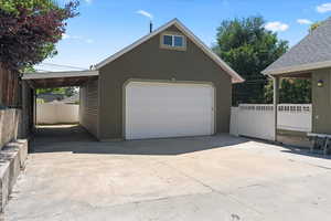 Oversized detached heated garage with loft storage and carport on east side of the home