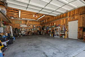 Exterior Garage: Inside of the oversized garage showing depth, heater and stairs leading to loft storage