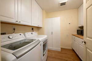 Large laundry room off kitchen with ample storage and countertop.