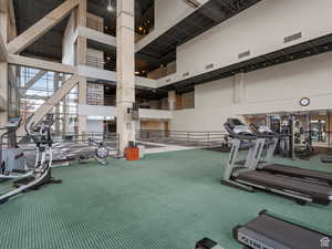 Exercise room with a high ceiling and carpet flooring