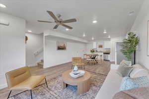 Living room with light wood-type flooring and ceiling fan