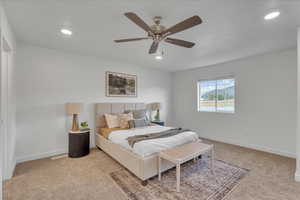 Carpeted bedroom featuring ceiling fan