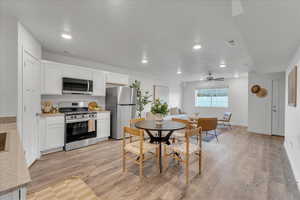 Dining room with ceiling fan and light wood-type flooring