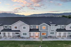 Back house at dusk featuring a mountain view and central AC