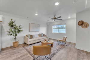 Living room with light wood-type flooring and ceiling fan