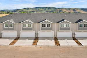 View of front of home with a garage and a mountain view