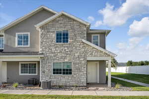 View of property featuring a front yard and central AC unit