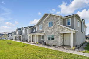 View of front of property with a front lawn and central AC unit