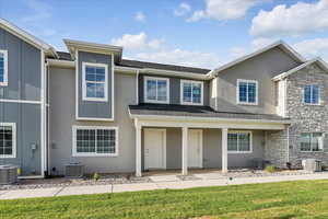 View of front of property featuring a front yard and central air condition unit